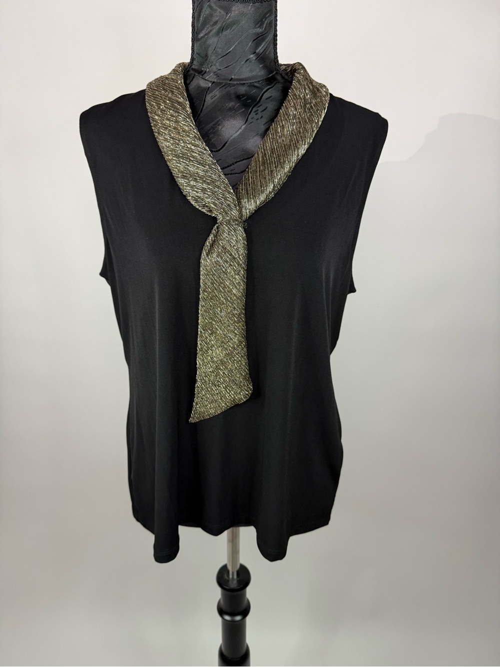Tahari sleeveless top featuring a v-neckline with metallic gold knot accent